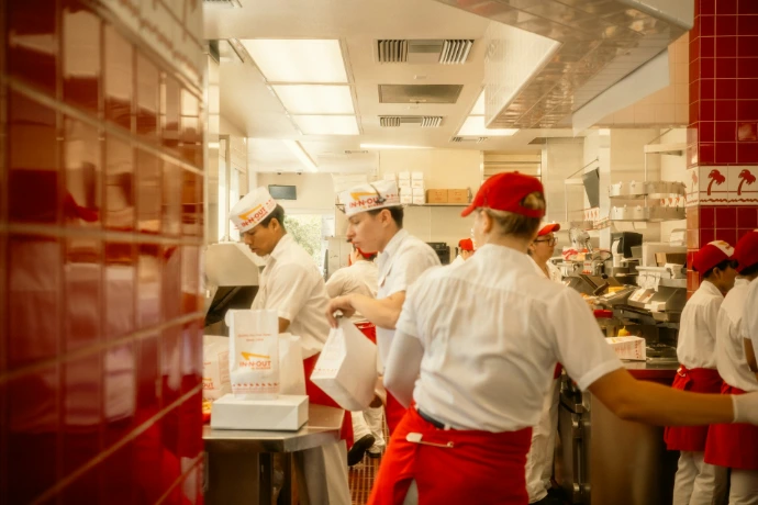 Restaurant workers preparing food in a busy kitchen.